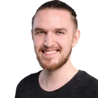 Denis Paris mit Zopf und Bart lächelt